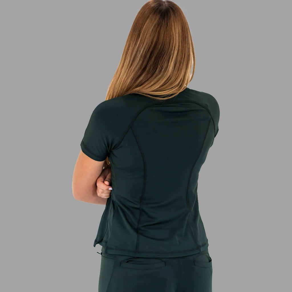 Back view of a woman in a bottle green 920 super stretch scrub top with crossed arms.