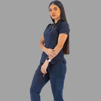 Full body three-quarter view of a woman posing in a navy blue Style 930 scrub top and matching scrub pants.