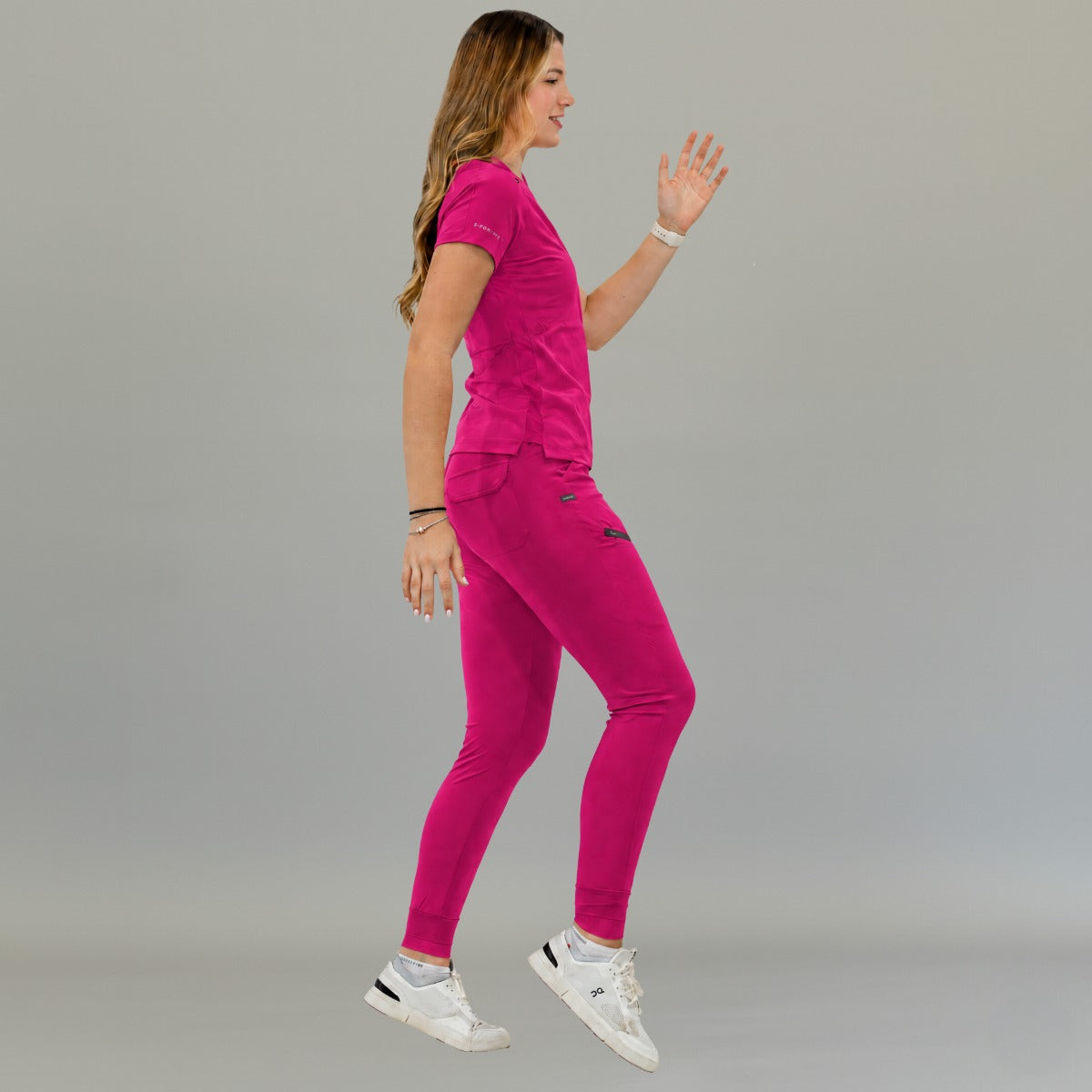 Filipina quirúrgica mujer 905 en fucsia, vista lateral en una postura dinámica con un brazo levantado.